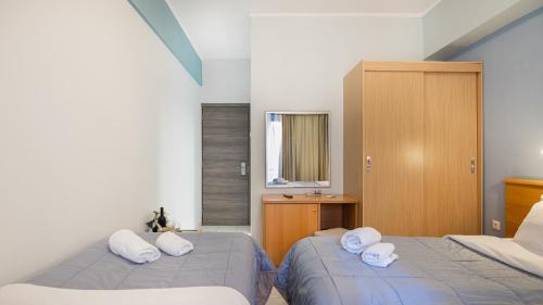 a bedroom with two beds with white pillows at Diros Hotel in Athens
