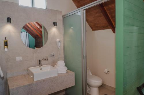 a bathroom with a sink and a toilet and a mirror at Selina Mancora in Máncora