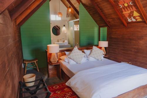 1 dormitorio con 1 cama con sábanas blancas y paredes verdes en Selina Mancora en Máncora