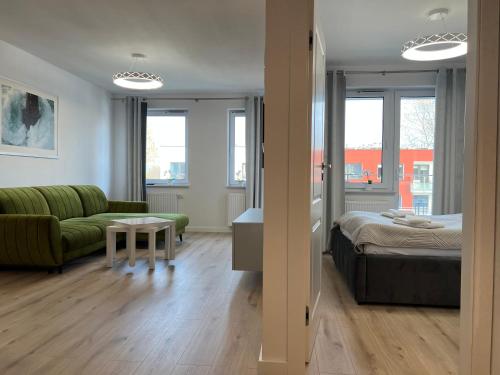 a living room with a bed and a couch at Cztery Pory Roku - 4 Seasons Kołobrzeg in Kołobrzeg