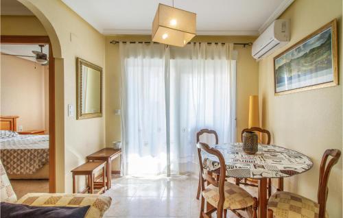 ein Wohnzimmer mit einem Tisch und ein Zimmer mit einem Bett in der Unterkunft Lovely Apartment In Santa Pola With Kitchenette in Santa Pola