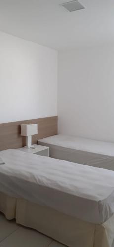 a bedroom with a large bed and a table at Residencial Iloa in Barra de São Miguel