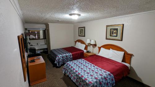 um quarto de hotel com duas camas e uma televisão em Eufaula Inn em Eufaula