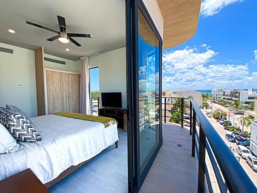 a bedroom with a bed and a balcony with a view at Beautiful + Luxury + Ocean View + Pool in Playa del Carmen