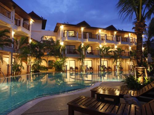 a hotel with a swimming pool at night at Fanari Khaolak Resort - Courtyard SHA Extra Plus in Khao Lak