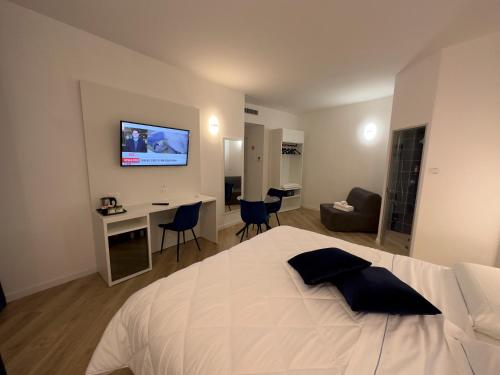 1 dormitorio con cama, escritorio y TV en la pared en Hotel Smart Cruise, en Civitavecchia