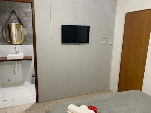 a bathroom with a tv on the wall and a bed at CASA MAR DE FORA in Fernando de Noronha