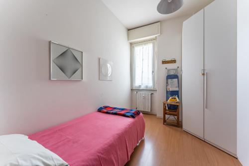 a bedroom with a bed with a pink blanket at Attico Montiglio - by Host4U in Brescia
