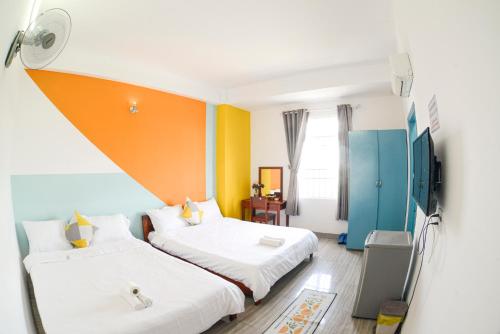 Dos camas en una habitación con naranja y azul en Hệ thống Myla - Trụ sở Ks Kim Liên, en Vung Tau