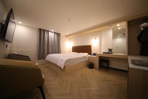 Uiwangにある25 Hotelのベッド、デスク、鏡が備わる客室です。