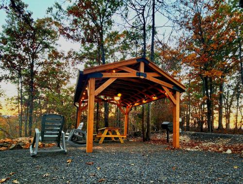 a wooden pavilion with a chair and a table at The Windstorm Cabin - Pet-friendly & a 2-person Jacuzzi hot tub! in Marshall