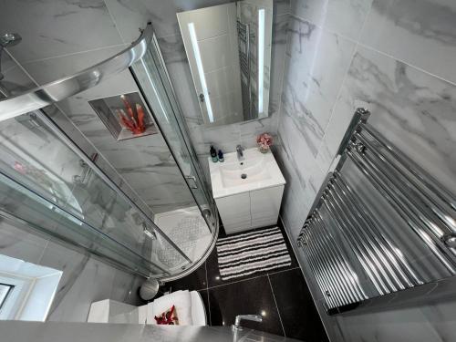 ein Badezimmer mit Waschbecken und Spiegel in der Unterkunft Aisiki Apartments at Stanhope Road, North Finchley, Airconditioned Multiple 2 or 3-Bedroom, Pet Friendly Duplex Flats, King or Twin Beds with Free Wi-Fi in Finchley