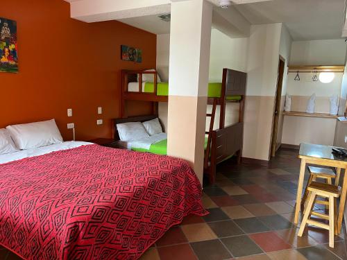 a room with a bed and a table in a room at Hostal Alpachaca - New Quito Airport in Tababela
