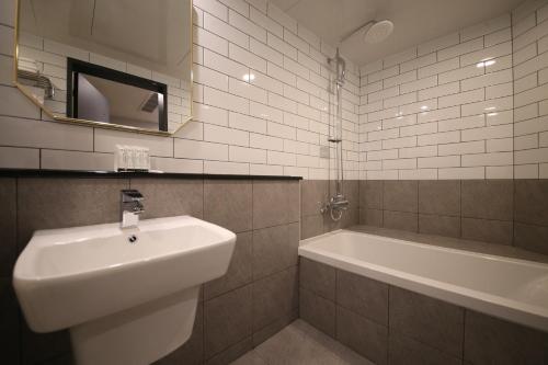 a bathroom with a sink and a bath tub at 25 Hotel in Uiwang