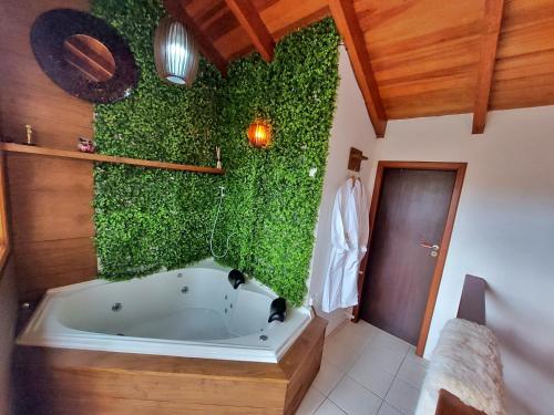 La salle de bains est pourvue d'une baignoire avec un mur vert. dans l'établissement Incrível Casa com Hidro-bikes-centro de Gramado 3Q, à Gramado