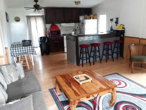 ein Wohnzimmer mit einem Tisch und einer Küche in der Unterkunft Overlook Lakehouse on Chippewa Lake Close to Haymarsh State Game Area and Ferris State College in Barryton