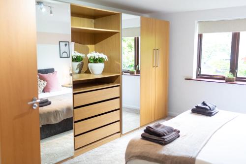 a bedroom with a mirror and two beds at Maltings House Cosy and Stylish 2 bedroom flat near the city centre with free parking and ensuite rooms in Carlisle