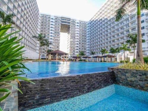 a large swimming pool in front of tall buildings at SHORE RESIDENCE D7 NEAR MALL OF ASIA & AIRPORT in Manila