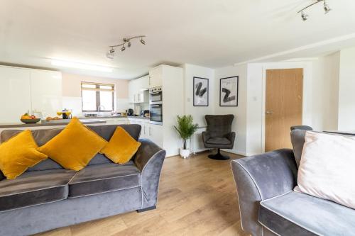 uma sala de estar com um sofá e uma cozinha em Maltings House Cosy and Stylish 2 bedroom flat near the city centre with free parking and ensuite rooms em Carlisle