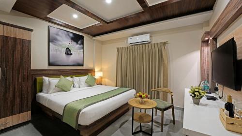 a hotel room with a bed and a television at Click Hotel Biz, Bangalore International Airport in Yelahanka