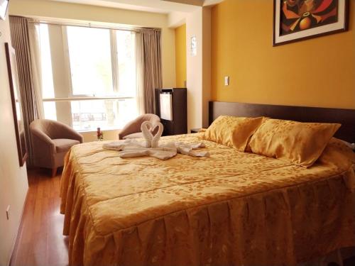 a bedroom with a bed with a towel on it at Hotel Dubái in Tacna