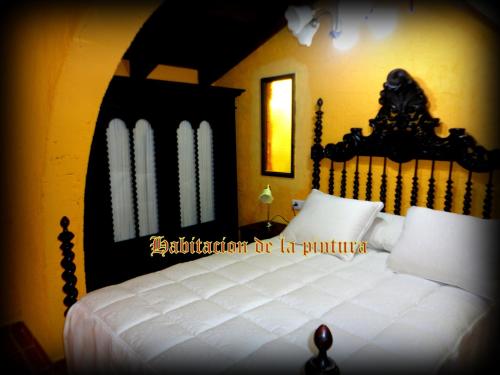 a bedroom with a large white bed with a black headboard at Caseria la Infiesta in Caleao