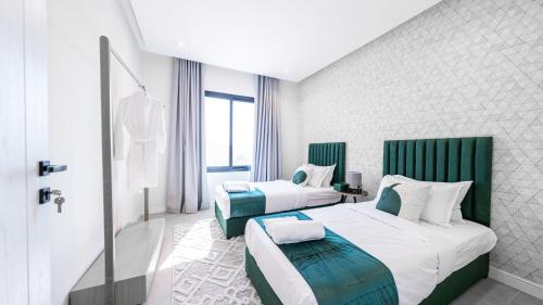 a hotel room with two beds and a window at Mabaat-Superior 2BR-Al Aqiq 399 in Riyadh
