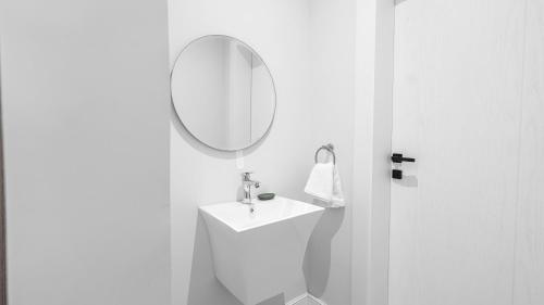 a white bathroom with a sink and a mirror at Mabaat - Al Aqiq - 399 in Riyadh