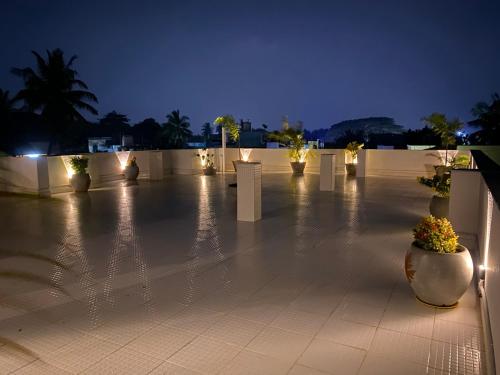 un patio iluminado por la noche con flores y luces en La Paradise Luxury en Pondicherry