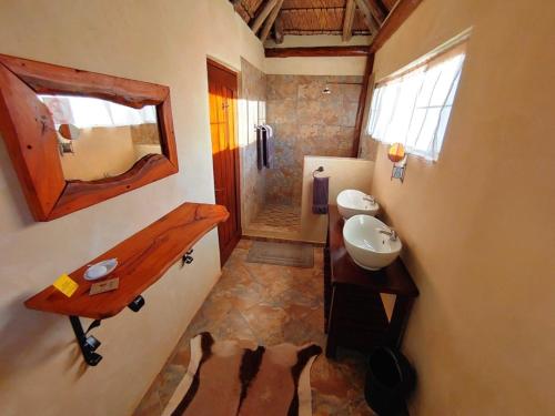 La petite salle de bains est pourvue d'un lavabo et d'un miroir. dans l'établissement Berchtesgaden Game Ranch & Lifestyle Farm, à Vaalwater