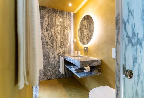 a bathroom with a stone sink and a mirror at CASA 3 - OS LUGARES DE CASTRALEUCA in Castelo Branco
