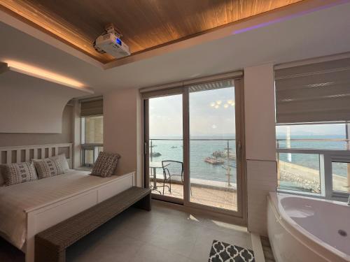 1 dormitorio con cama, bañera y ventana en Somewhales Pension, en Namhae