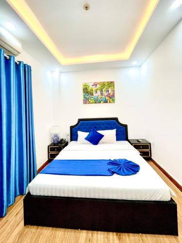 a bedroom with a large bed with blue curtains at Thuy Duong Boutique Hotel Hue in Hue