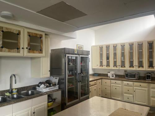una cocina con nevera de acero inoxidable y armarios de madera en Casa Escalante Hostel, en San José