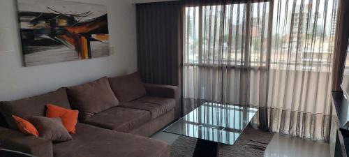 sala de estar con sofá y mesa de cristal en El balcón de G. en Salta
