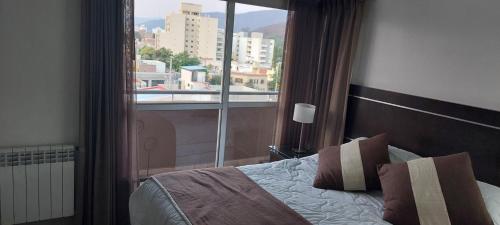1 dormitorio con cama y ventana grande en El balcón de G. en Salta