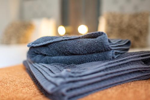 a stack of blue towels sitting on a table with candles at Logan House, Modern and Spacious Townhouse close to City Centre in Carlisle