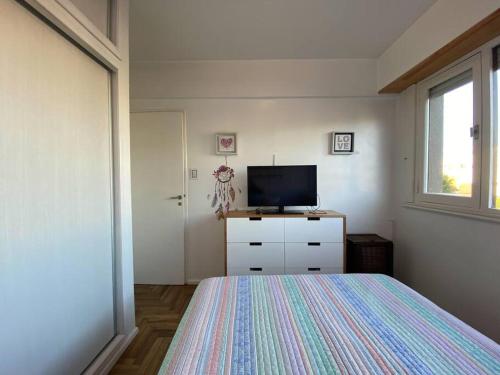 1 dormitorio con cama y vestidor con TV en Acogedor departamento 2 amb - Excelente ubicación en Mar del Plata