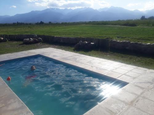 圖努揚的住宿－Casa de Campo Finca La Angelita，在田野游泳池游泳的人