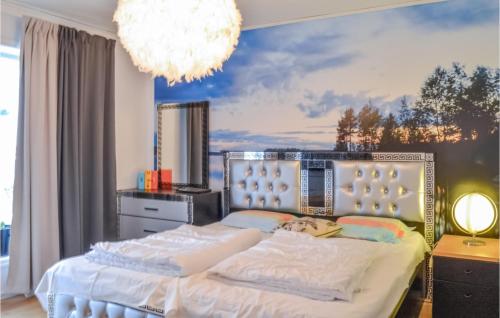 ein Schlafzimmer mit einem großen Bett und einem Kronleuchter in der Unterkunft Awesome Home In Djurhamn With Kitchen in Djurhamn