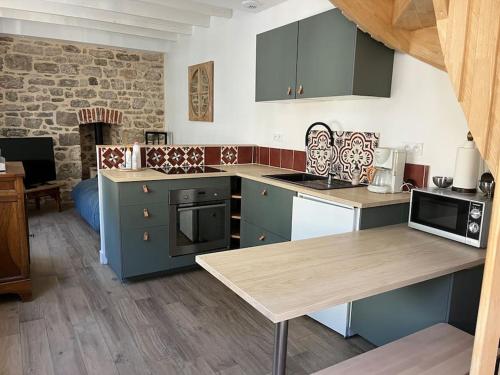 une cuisine avec des placards verts et un comptoir dans l'établissement Appartement de charme en cœur de ville, à Guingamp