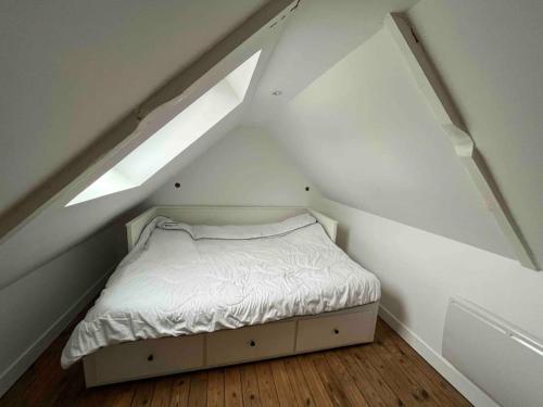 ein kleines Schlafzimmer mit einem Bett im Dachgeschoss in der Unterkunft Appartement de charme en cœur de ville in Guingamp