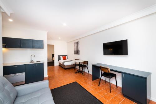a kitchen and living room with a couch and a table at River Motel in Queanbeyan
