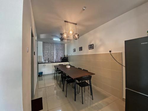 Un comedor con una mesa y algunas sillas. en Desaru Vacation Home KTV-BBQ-Netlfix-Games Near WaterPark, en Kampung Tanjung Agas
