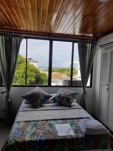a bedroom with a bed and a large window at Apartahotel Isla Fuerte Piso 4 in Cartagena de Indias