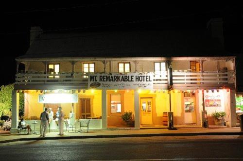 two people standing in front of a building at night at Mt. Remarkable Hotel Motel in Melrose