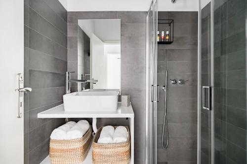 a bathroom with a sink and a shower with baskets at 30villa Rd in Rhodes Town