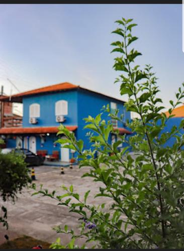 a blue building in front of a parking lot at Pousada Miragem Do Mar Cabo Frio Praia Do Peró in Cabo Frio