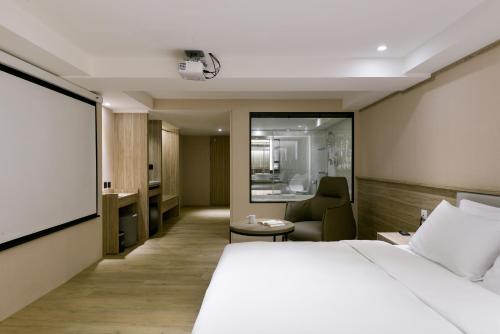 a hotel room with a bed and a chair at Spring Rhapsody Hotel in Taichung