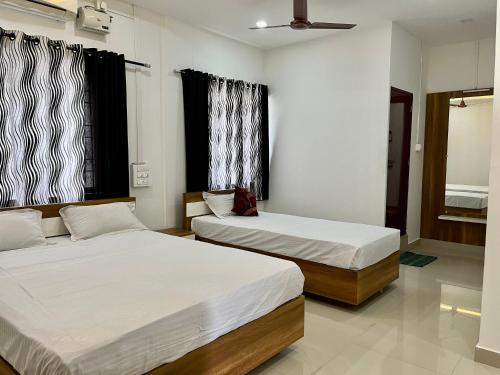 a bedroom with two beds and a window at The Grand Inn in Kanjikode